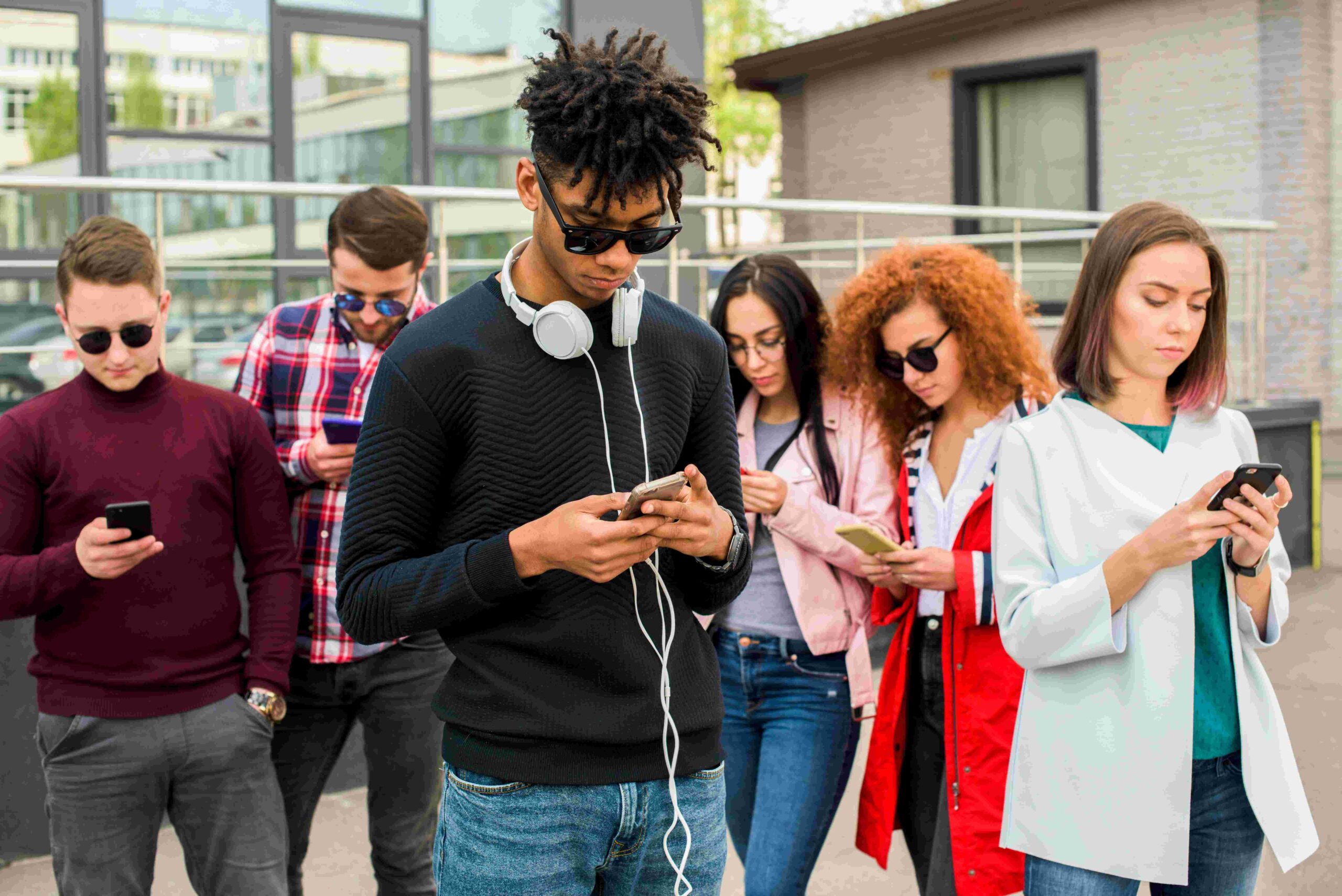 young-african-man-standing-front-his-friends-using-mobile-phones-compressed (2)